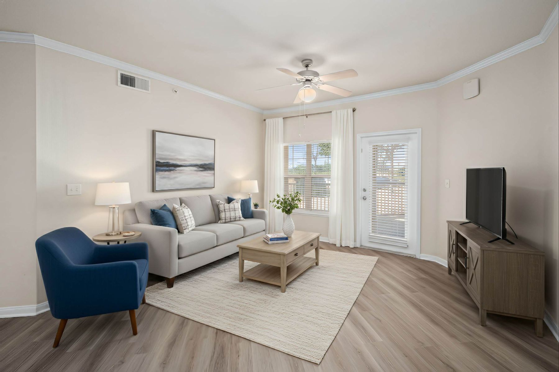 Empty room with wood floors, ceiling fan, and sliding glass door leading to a patio with vertical blinds at Apex West Midown.